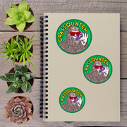a spiral notebook with stickers on it, surrounded by various potted plants.