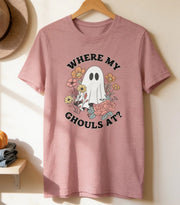 a pink t-shirt hanging on a wooden hanger, with a hat and two pumpkins placed on a shelf below it.