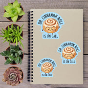 a notebook with stickers on it, along with several potted plants arranged on a wooden surface.